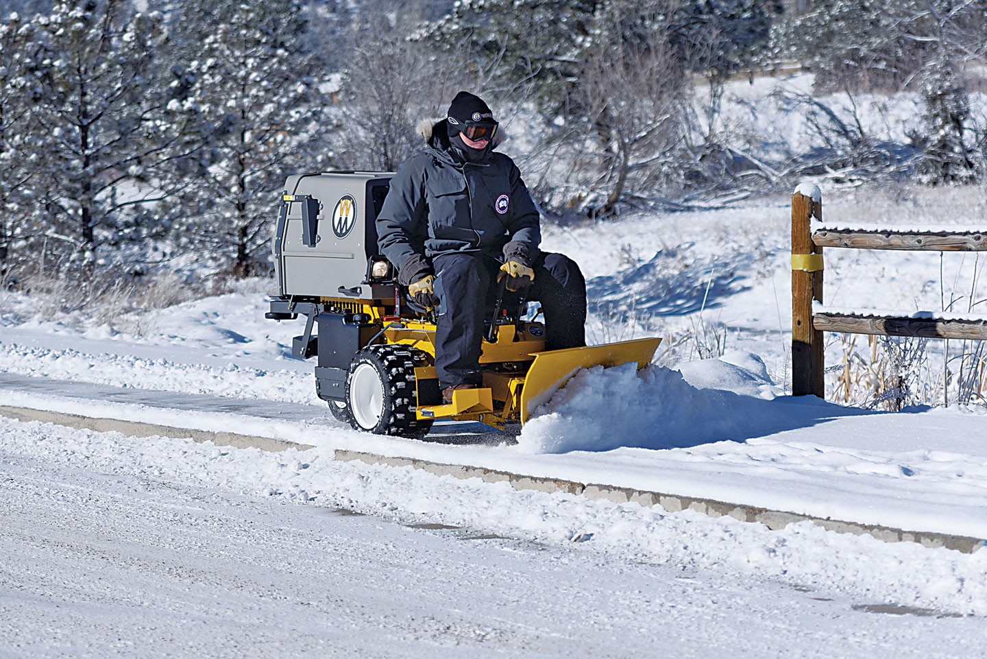 Riding snow plow clearing sidewalks